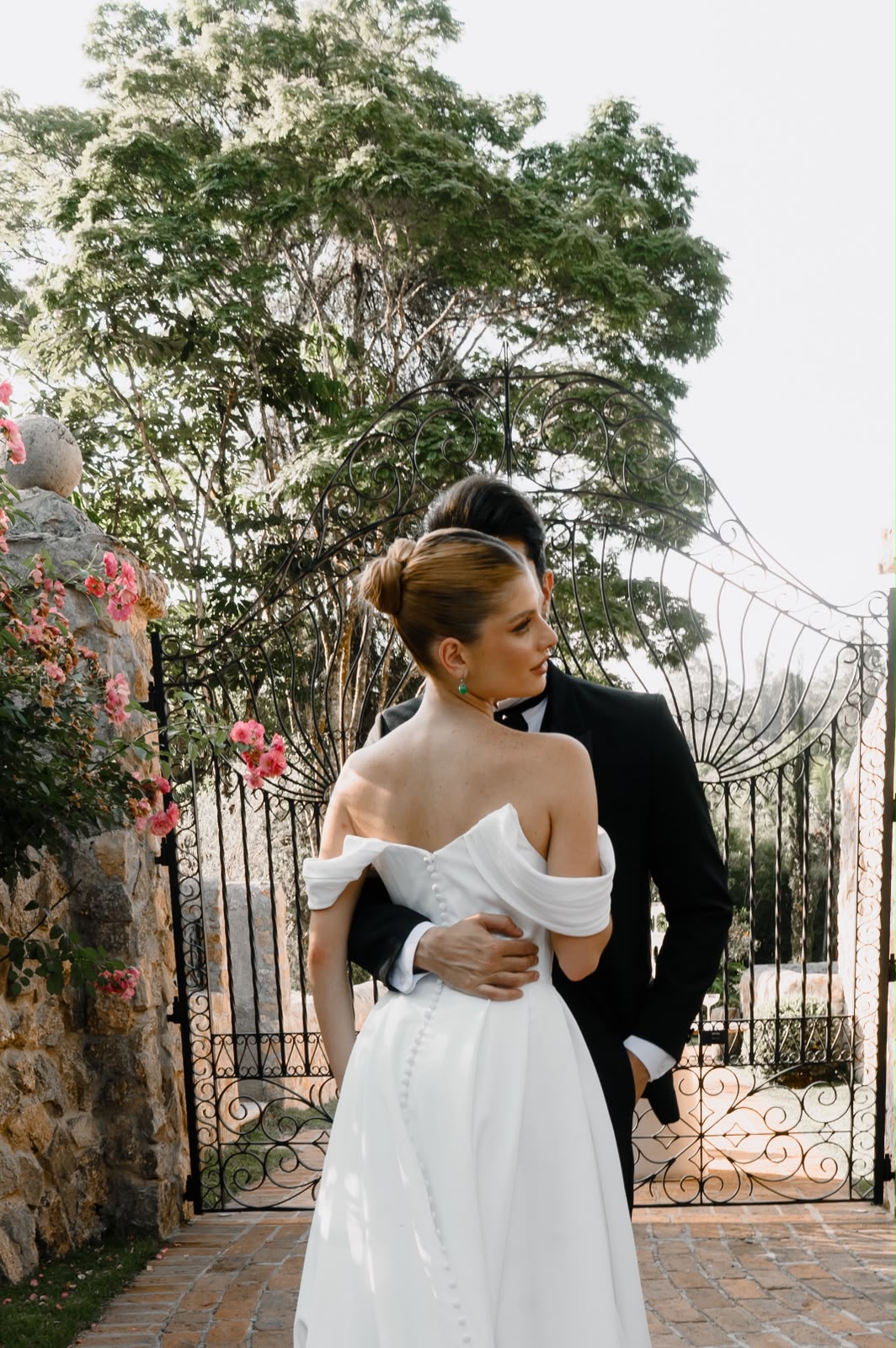 Casal de noivos junto ao portão do jardim